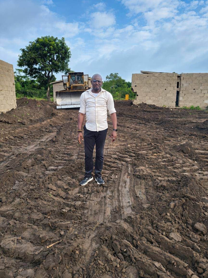 Cleared ground at the refinery site with a bulldozer and the first block walls